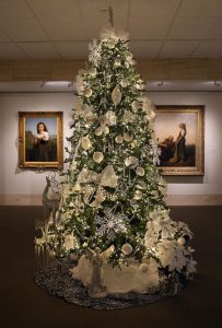 A christmas tree decorated in silver and white in a museum gallery