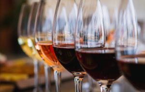 Wine glasses in a row, each filled with a different type of wine.